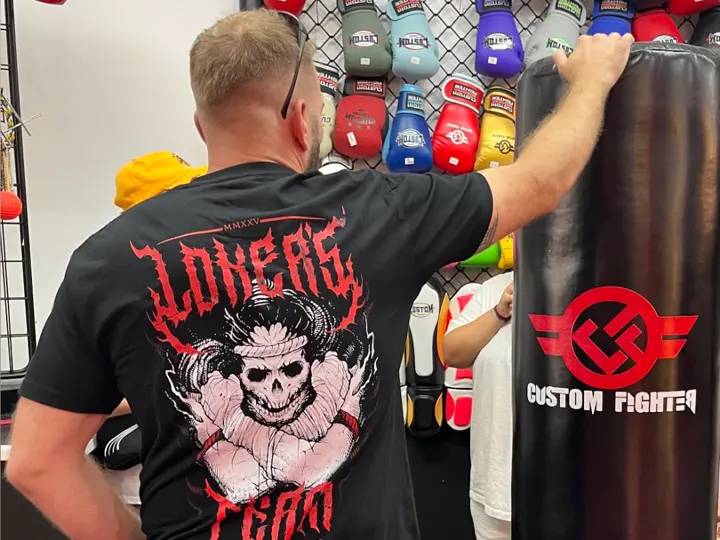 Alejandro Tebar, de espaldas, junto a un saco y una pared de guantes.