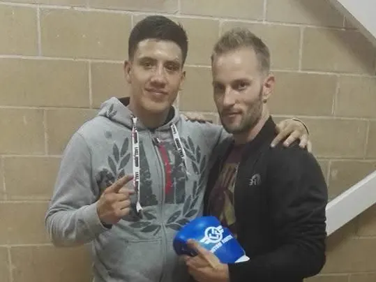 Alejandro Tebar y otro deportista en una velada. Uno de los dos sostiene un guante azul.